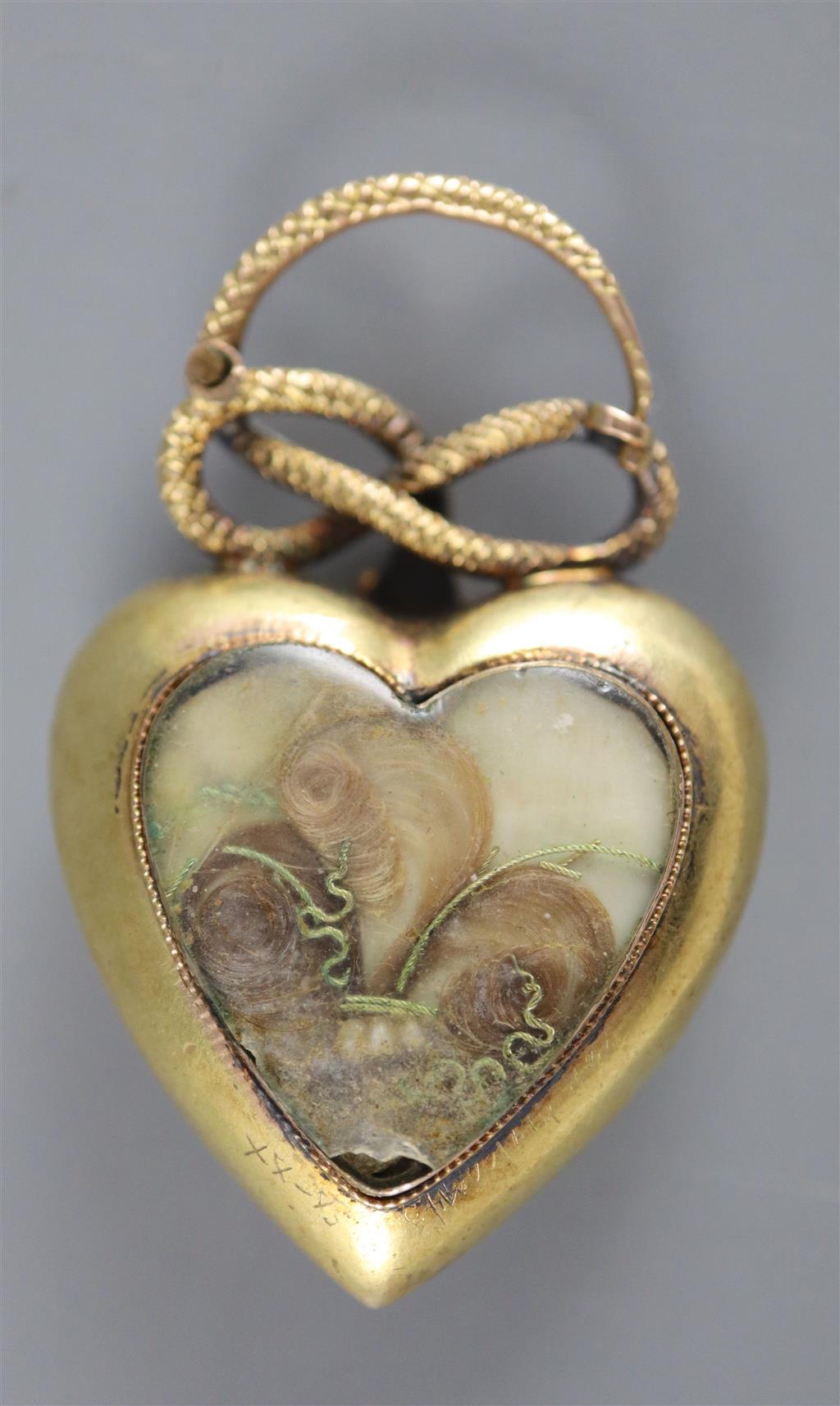 A Victorian gold and gem set heart shaped mourning pendant, with hinged serpent finial,